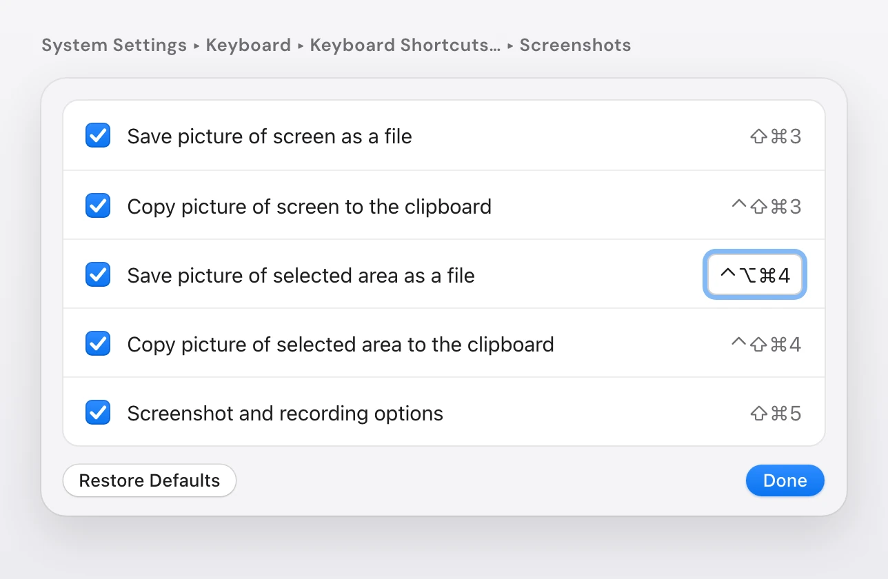 The Screenshots list in System Settings keyboard shortcuts, with Save picture of selected area as a file being changed to Control-Option-Command-4, above Restore Defaults and Done